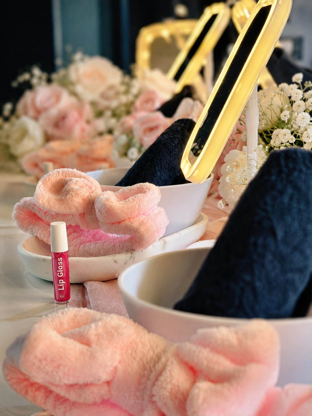 Mini Luxe Spa Party detail with lip gloss, pink headbands, white bowls, navy towels and illuminated mirrors.
